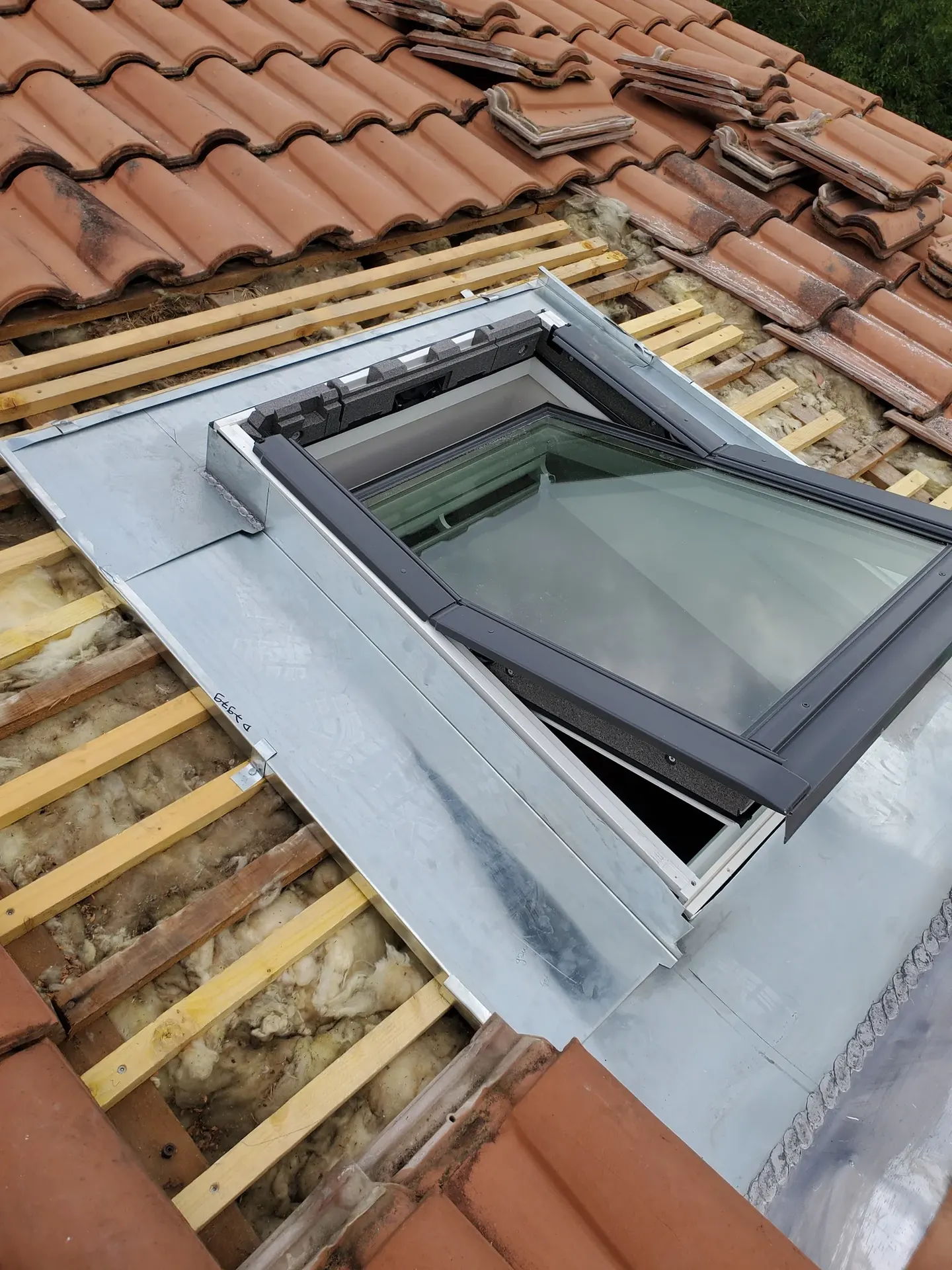 Pose d'une fenêtre de toit avec son raccord d'étanchéité en zinc