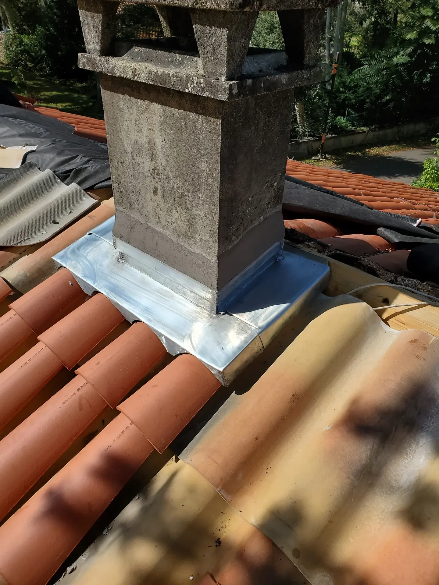 Abergement de cheminée en zinc sur une toiture en tuiles