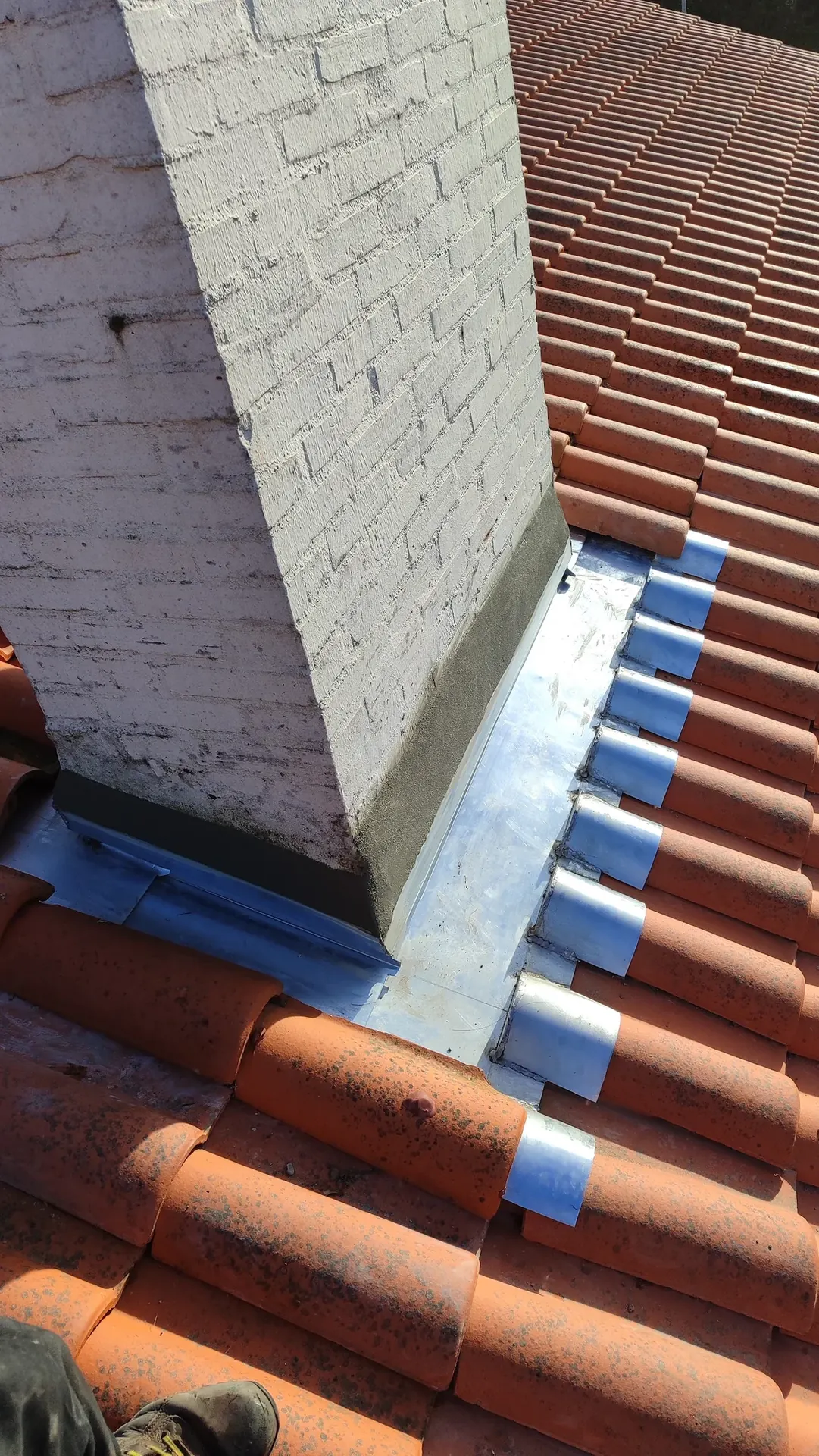 Abergement de cheminée en zinc sur une toiture en tuiles